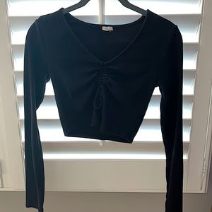Store: Garage.   Black long sleeve cropped top.